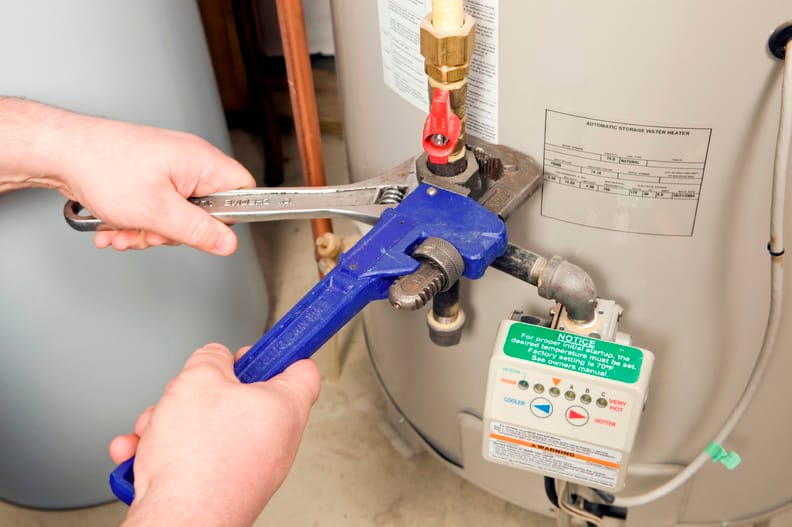 Plumber repairing a water heater valve in San Marcos
